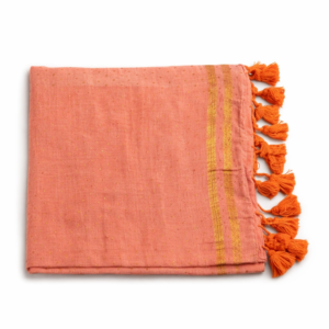 Peach-orange Mul cotton saree with golden zari border stripes and orange tassel detailing.