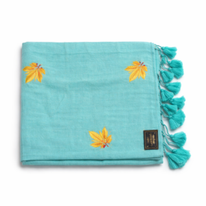 Seafoam blue Mul cotton saree with intricate yellow leaf embroidery and matching blue tassels.